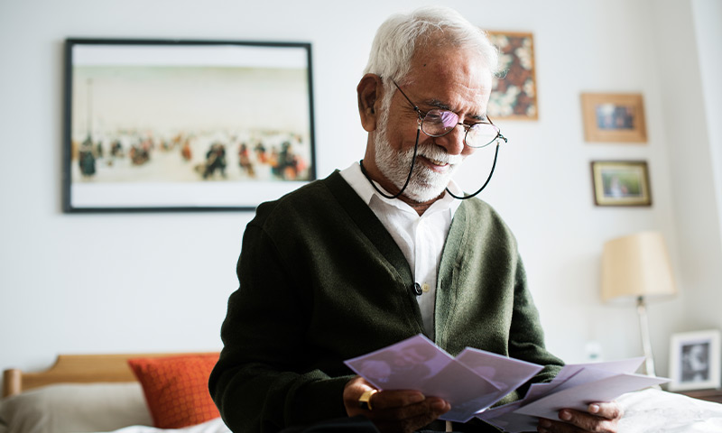 elderly man reviewing financial bills safe retirement plan