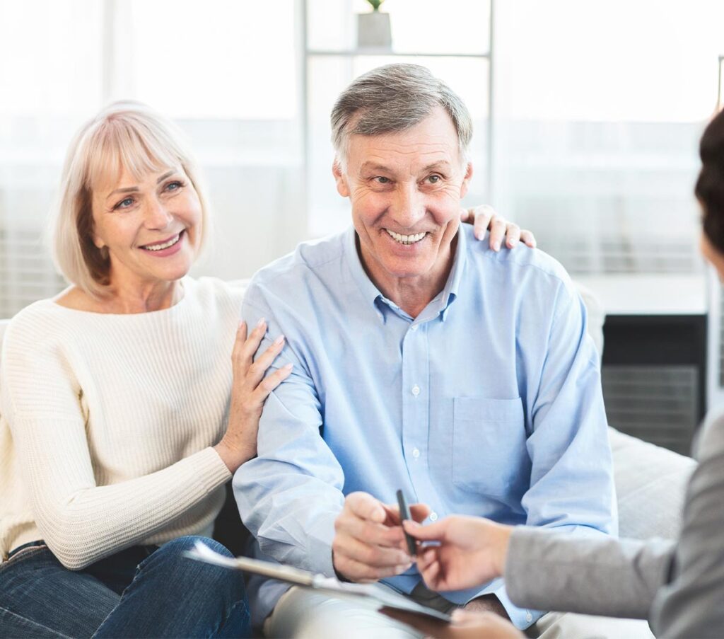 smiling senior couple meeting with financial advisor to discuss financial planning for retirement